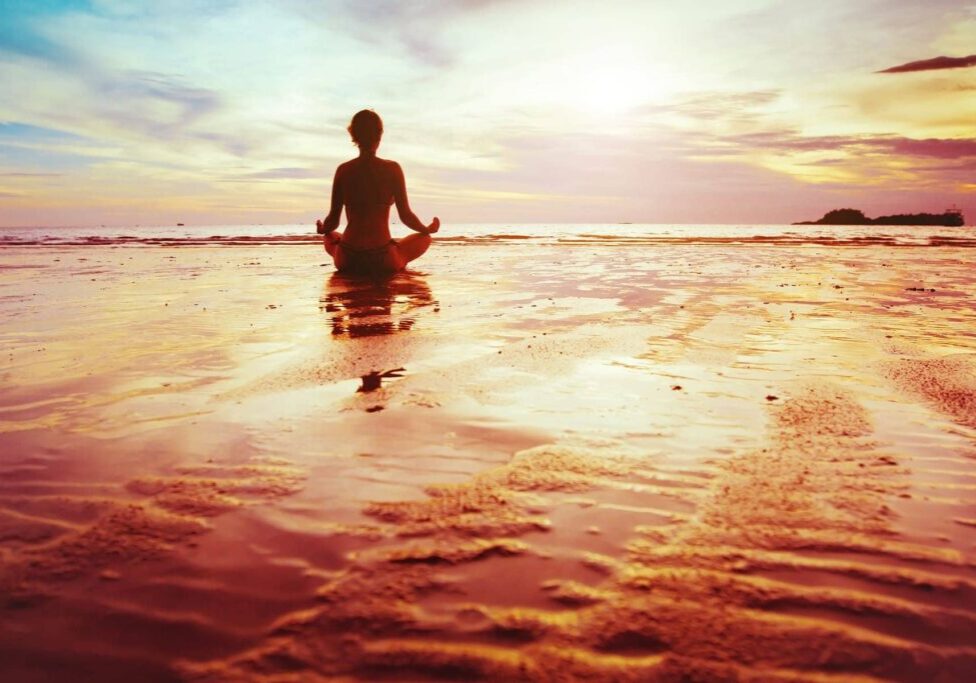 enlightenment, silhouette of woman practicing yoga on the beach